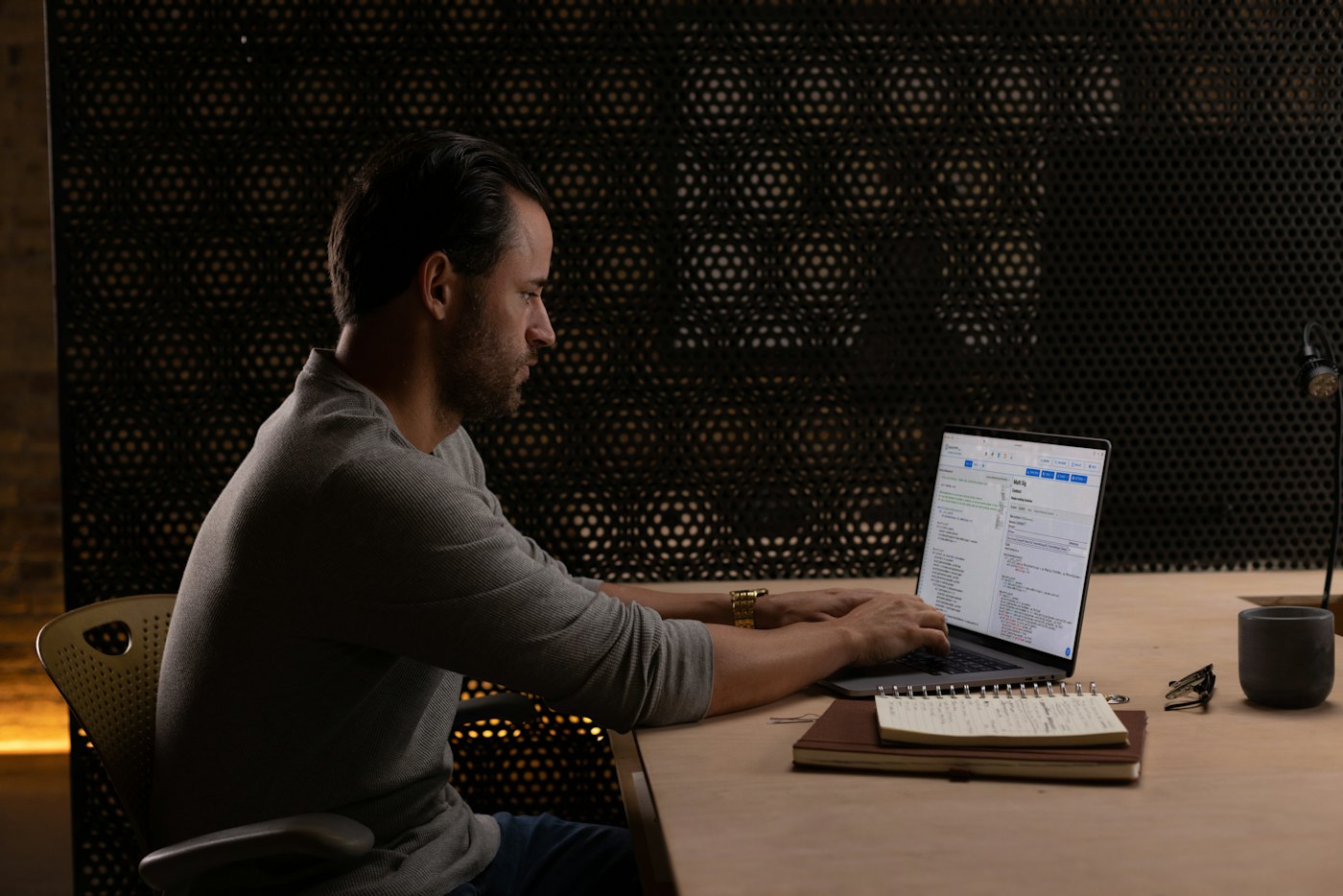 A person working at a laptop in a dark room