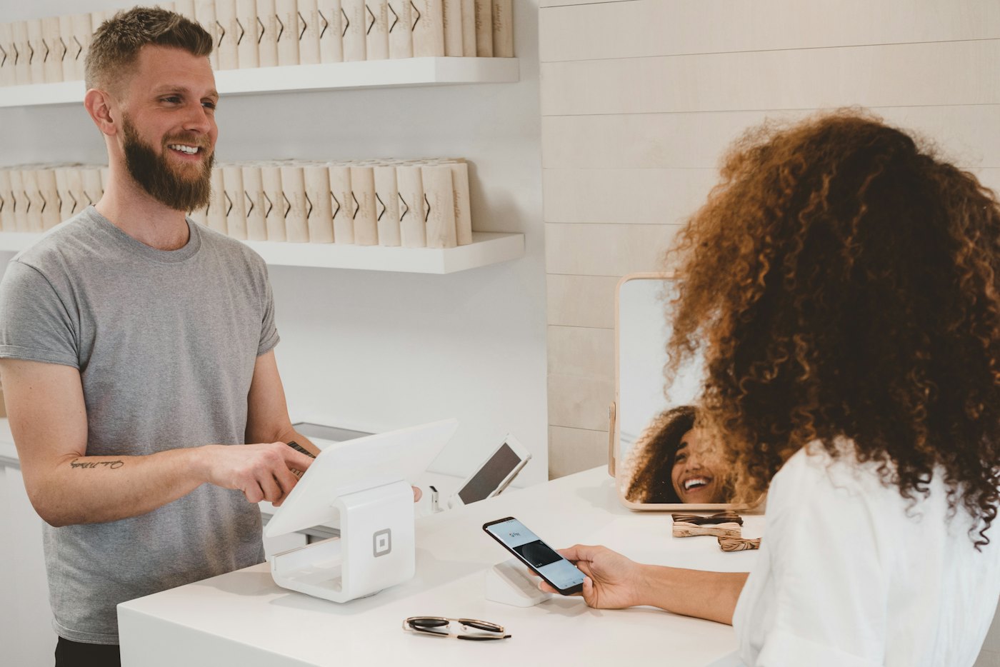 A customer paying by phone at a shop counter